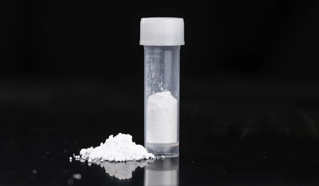 White barium sulfate powder in a transparent vial with a small pile
